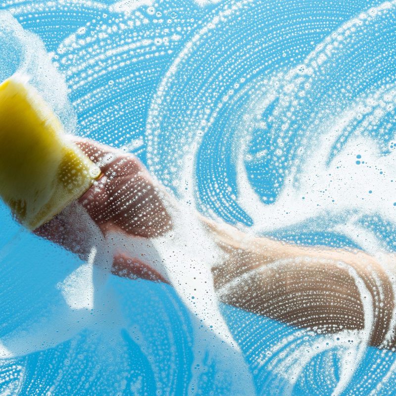 Man washing front window with sponge